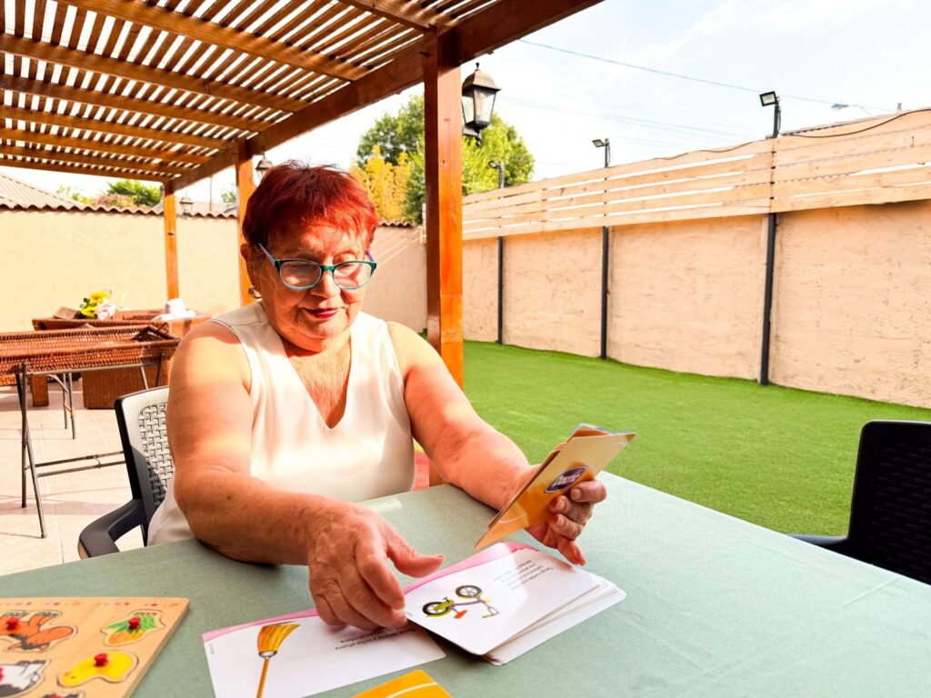 Actividad con cartas en la terraza de una guardería para adulto mayor